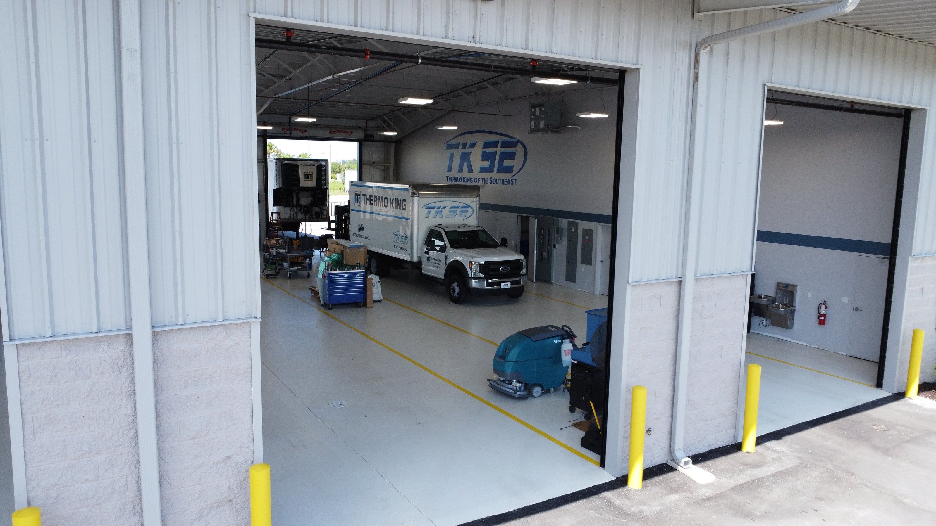 An open bay at TKSE's Fort Pierce shop, with a TKSE service truck and a Thermo King trailer unit inside